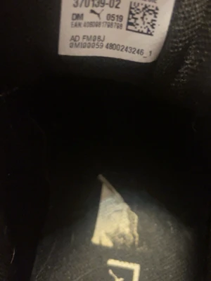 Svarta Puma sneakers med vit sula - Snygga svarta sneakers från Puma med glansig finish och kraftig vit sula. Skorna har svarta skosnören och diskret Puma-logga på sidan. Perfekta för dig som gillar en sportig och trendig look.