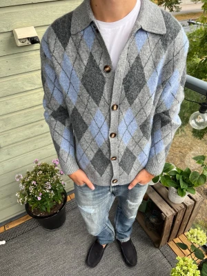 Grå argyle kofta från Topman - Kofta från Topman i grått med klassiskt argylemönster i ljusblått och mörkgrått, passfromen är slapp och sitter riktigt skönt!✅. Storlek S men passar mer som M. Nyskick skriv vid funderingar och följ för mer!