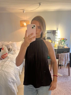 Svart halterneck topp med ribbad struktur - En brun halterneck topp med ribbad struktur och hög hals. Toppen är ärmlös och har knyt i nacken, aldrig använd💗