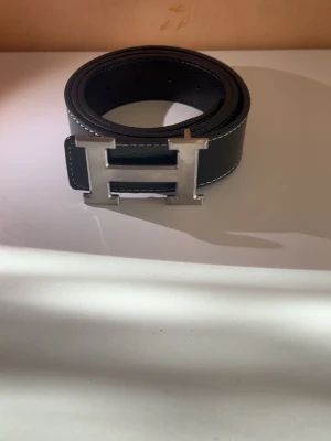 Svart H bälte - Ett helt nytt svart H bälte storlek 110,perfekt för att ge en lyxig tuch till din outfit 