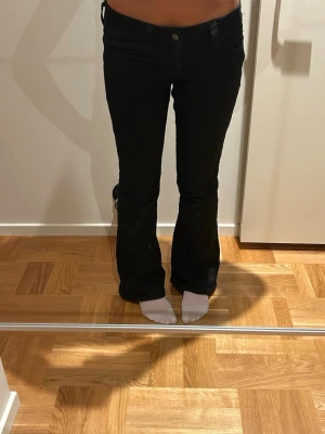 Svarta bootcut jeans Cheap Monday - W26/L30. Säljer ett par svarta bootcut jeans från Cheap Monday. Jeansen har klassisk femficksmodell, normal midja och är tillverkade i stretchigt denimtyg. Snygg Cheap Monday-logga bak i lila och svart. Perfekta för dig som gillar en retro vibe.