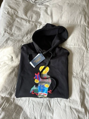 Ralph Lauren Hoodie - Svart hoodie från Ralph Lauren (HELT NY). Tyvärr fick jag aldirg chansen att använda tröjan själv då den inte passade mig så jag säljer nu denna till en av er där ute. Inga defekter, lappar finns kvar. Skriv vid funderingar, vi hörs!