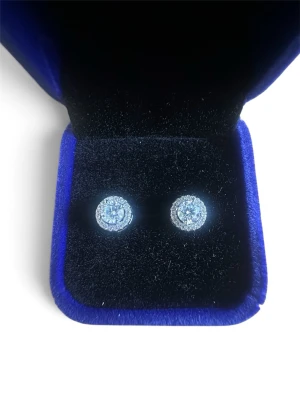 Moissanite Örhängen 0.5ct D VVS1 (Halo) - Helt nya och oanvända örhängen med halo-inramning. Stenarna är äkta moissanite (testade med diamanttestare) i högsta kvalitet: 0.5 carat styck (5.0 mm), färg D (färgslös), klarhet VVS1 och utmärkt slipning (Excellent Cut). Infattade i S925 sterlingsilver med platinaplätering. Levereras med GRA-certifikat, garantikort och en snygg blå sammetsask. Skickas snabbt och tryggt! 