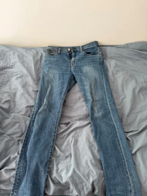 Blå bootcut jeans med slitningar - Snygga blå bootcut jeans i klassisk femficksmodell med lätt slitna detaljer framtill och bakfickor. Jeansen har normal midja och är gjorda i denim med en skön tvättad look. Perfekta för en avslappnad och trendig stil.