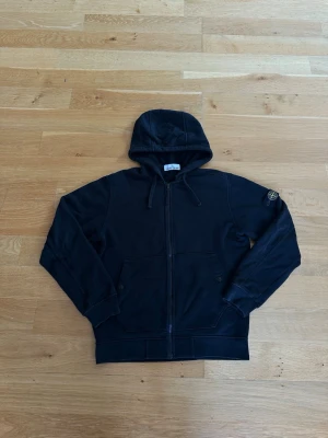 Stone Island hoodie - Svart zip hoodie ifrån Stone Island i mycket bra skick! Har liten defekt vid luvans närmast dragkedjan (Bild 3) 