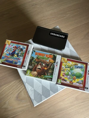 Nintendo 3DS med tre spel - Säljer en svart Nintendo 3DS tillsammans med tre spel: Mario Party Island Tour, Donkey Kong Country Returns 3D och Yoshi's New Island. Konsolen är kompakt och har en stilren design i plast. Perfekt för dig som gillar klassiska Nintendo-spel.