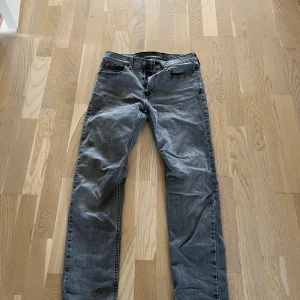 Grå Levis 502 - Säljer ett par grå Levis 502 jeans med klassisk femficksdesign och raka ben. Jeansen har en snygg tvättad look och är tillverkade i mjukt jeanstyg. Passar perfekt för dig som gillar en enkel och stilren stil.