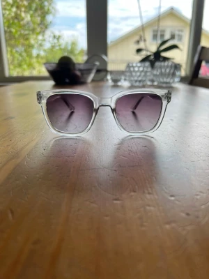 Transparenta fyrkantiga solglasögon - Snygga solglasögon med transparent, fyrkantig båge och mörka tonade glas 🤩Ramen är i plast och ger en modern och stilren look. Perfekta för dig som vill ha en clean accessoar😅