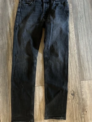 Svarta slim fit jeans - Snygga svarta jeans i slim fit-modell med klassisk femficksdesign och raka ben. Jeansen har kontrastsömmar och är tillverkade i ett mjukt denimtyg med lite stretch för extra komfort. Perfekta för en avslappnad och trendig look.
