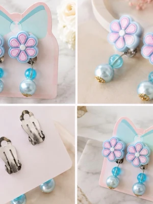 Blommiga clipsörhängen med pärlor - Säljer ett par söta clipsörhängen med blå och rosa blommor upptill och två blå pärlor som hänger ned. Örhängena har en lekfull design med metallclips på baksidan och detaljer i guld på pärlorna. Perfekta för dig som vill ha något gulligt och färgglatt för barn.