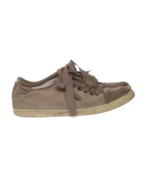 Lanvin sneakers med breda snören - Säljer ett par äkta bruna låga lanvin sneakers med breda matchande snören och beige sula. Skorna har en enkel och stilren design i mockaliknande material och passar perfekt till en avslappnad streetwear-look.