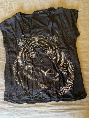 Svart t-shirt med tigertryck stl.L - Cool svart t-shirt med ett stort tigertryck, stl.L, bomull och viskos