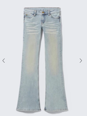 Ljusblå bootcut jeans med slitningar - Storlek: 28/32. Säljer ett par ljusblå bootcut jeans med snygga slitningar och tvättade detaljer framtill. Små defekter längst ner där bak vid fötterna men ingeting som syns när man har på dom. Modellen bär samma storlek som jag säljer.
