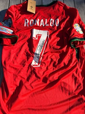 Ronaldo #7 – Signerad Portugal EM 2024 (storlek L) - Ronaldo #7-tryck. Portugal EM 2024. Storlek L. Signerad tröja. Helt ny och aldrig använd. Skickas snabbt 🚚💨  🔥 Fan Edition – normal och bekväm passform. 🇵🇹 Portugal landslag.  📩 Skicka gärna ett meddelande vid frågor eller prisförslag! 🛍 Bundle-rabatt upp till 20%! 📦 Skickas samma eller nästa dag.