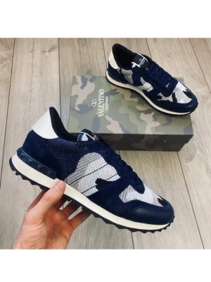 Valentino Rockrunners  MÖRKBLÅ camo sneakers - Snygga sneakers från Valentino i blått och vitt med camo-mönster. Skorna har en mix av mocka och textil, svarta snören och vit häl. Sula med nitar baktill och cool design som sticker ut. Sköna skor från valentino passar perfekt för Höst och sommaren i storlek 44. Marinblå,vitt.