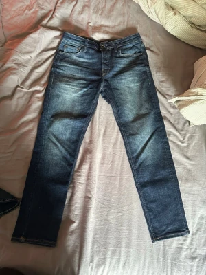 Jack & Jones jeans - Säljer ett par mörkblå jeans från Jack & Jones i modellen tapered/mike, storlek 32x30 som är använda 2-3 gånger. Hör av dig om du har några funderingar!