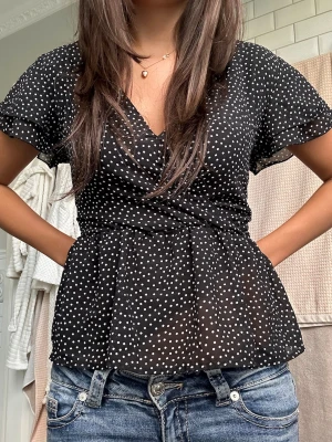 Svart polkadot omlottblus - Polkadot blus , super fin , säljer för jag inte fått en chans att ha på mig den tyvärr , helt ny , är marinblå i vissa ljus 