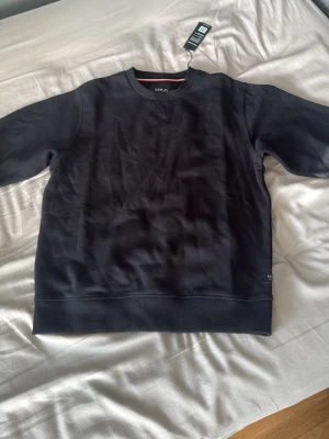 Svart sweatshirt från Replay - Säljer en stilren svart sweatshirt från Replay med rund halsringning och ribbade muddar. Tröjan har en diskret logga vid nederkanten och klassisk passform. Perfekt till jeans eller joggers för en avslappnad look.
