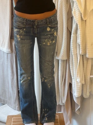 Niche Lågmidjade bootcut jeans  - .De har glittriga detaljer och coola niche vita fläckar på , jätte bra skick. Midjemått rakt över : 41 innerbens längd : 77