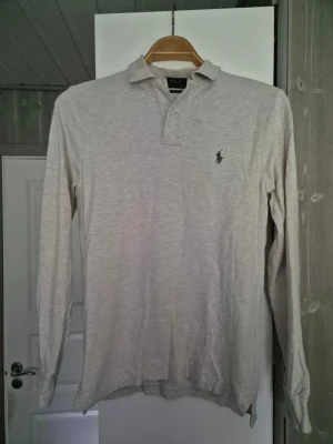 Ralph Lauren Långärmad Smalm - Fin fräsh Ralph Lauren beigh. Inköpt för 2 år sedan. Använt sparsamt då den blev för liten.