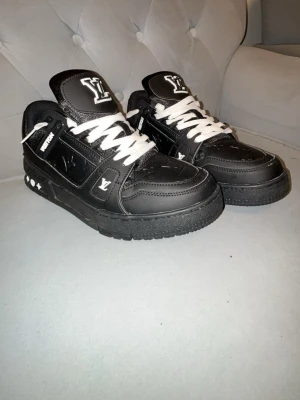 Svarta  sneakers - Stilrena svarta  sneakers med vita detaljer och vita skosnören. tungan, samt mönster i svart och vitt på sulan. Tillverkade i läder med robust sula och låg profil.