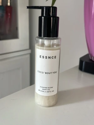 ESSNCE Coco 'Bout You Body Oil - Scented Glow Body Oil från ESSNCE i doften Coco 'Bout You. Innehåller kokos, piña colada och vanilj för en tropisk känsla. Kommer i en genomskinlig plastflaska med svart pump och vit etikett. Volym: 100 ml.