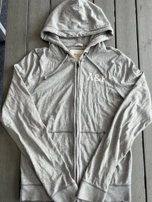 Abercrombie & fitch zip hoodie grå vintage - Riktigt snygg Abercrombie zip hoodie. fint skick inga fel storlek L kan ta mått vid behov. Endast 278kr ej hugget i sten kom gärna med frågor och prisförslag har även mycket mer liknande i min profil alla storlekar kolla gärna stor rabatt vid köp av flera 😁✌️