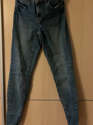 Blå skinny jeans från Pieces - Säljer ett par blå skinny jeans från Pieces i storlek S. Jeansen har klassisk femficksmodell, normal midja och smal passform hela vägen ner. Materialet är mjukt denim med lätt tvättad look och subtila slitningar. Perfekta till vardagslooken!