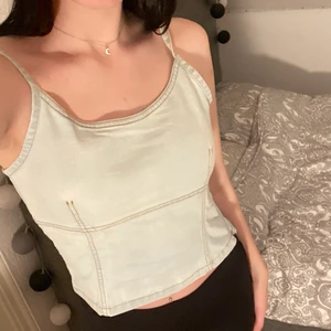 Jeanstopp ifrån CAM - Jeanstopp ifrån CAM med öppen rygg, har en osynlig dragkedja på sidan så att man lättare kan ta på sig den. Står att den är i storlek M, men passar även mig som är en S. (Bandet har snurrat sig på bilden!).