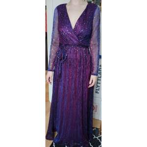 Helt ny, endast provad glittrig långklänning i en jättefint lila-blå skimrande material med paljetter. Storlek S/38. Perfekt till nyårsfirandet eller en bal! 