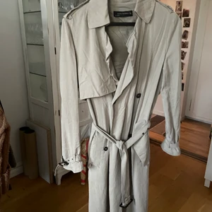 Rock från Zara - Beige rock/trenchcoat från Zara. Skrynklig då den legat nedpackad. Bra skick! Den är lång även om det inte syns på bilderna. 