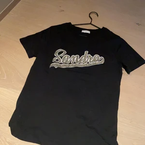 cool sandro tröja strl 1 (motsvarade S) - Väldigt bra skick. svart t-shirt med guld text