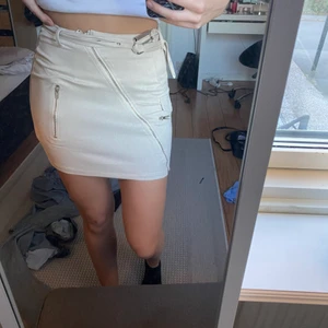 Beige tajt kjol  - En beige tajt kjol med silvriga detaljer i mocka. Kommer från pretty little things, den är aldrig använd och har kvar prislapp på sig! 🥰