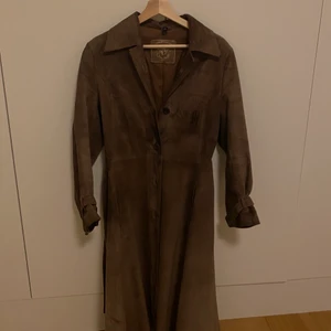 Mocka trenchcoat - Mammas gamla trenchcoat i brun mocka från när hon var ung. Otroligt fin men har tyvärr blivit lite liten på mig, passar storlek 34-38 beroende på vilken passform man vill ha ☺️