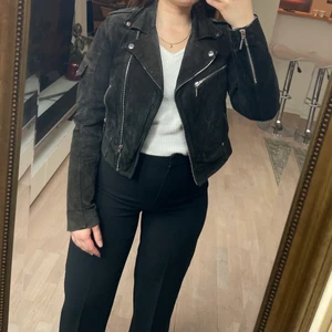 Kort mockajacka  - Säljer en kort mockajacka i sliten svart färg i storlek S. Silvriga detaljer och fin passform.
