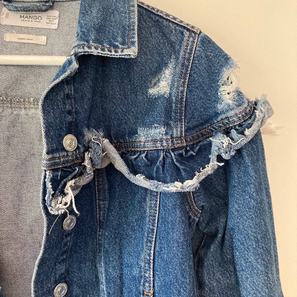 Jeansjacka av kortare modell med volang och slitna detaljer från Mango. Står ”One size” på etiketten men skulle säga att den passar en storlek S. . Jackor.