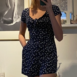 Mörkblå jumpsuit - En mörkblå jumpsuit med vita blommor från hollister. Den är använd ett fåtal gånger under sommaren och är därför i väldigt fint skick. Undrar du något är det bara att skicka🥰