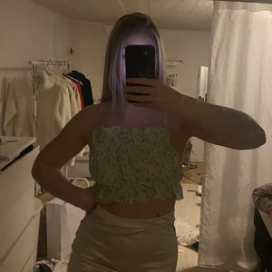 Topp - Grön topp från H&M med blommor, banden är justerbara! Endast kommit till användning en gång, därav säljer jag den! ❤️ (priset kan ändras vid fler köp av plagg)