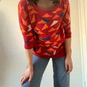 A cozy, mid-thigh length wool-blend sweater, with a fun geometric print. Sleeves are elbow-length, and fit is not baggy. The sweater is stretchy and can fit a size up or down.  Can be worn over dresses, skirts, or pants. The collar is a classic round collar. 