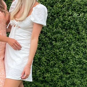 Sommarens sötaste klänning! - Super söt & skön vit klänning, med små utskurna ”blommor” & knytning & utskurning vid bysten! Super fin till student eller midsommar! Köpt från h&m i XXS men passar mig som vanligtvis har XS! Själv använt den 1 gång på midsommar! Frakt ingår i priset!