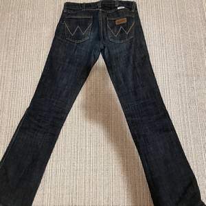 Mörkblåa bootcut/straight low waisted jeans från Wrangler. Är tyvvär lite tajta på mig. W26, L32. Midja: 74cm innerben: 78cm