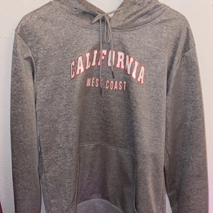 Grå hoodie  - Grå hoodie med tryck, säljer för att den inte kommer till användning längre, ganska tunt tyg, lite stor i storleken så passar även en medium