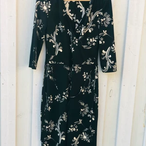 Klänning från H&M - Mönstrad klänning som känns festlig. Knytband runt midjan. Har själv använt denna på ett dop och en begravning. Inköpt för 10 år sedan 