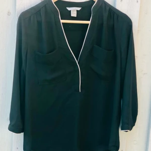 Blus från H&M - Svart blus med vit detalj från H&M. Använd vid ett par tillfällen. 