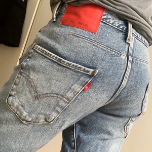 Levis twisted med slitna knän - Snygga och erhört bekväma jeans från Levis i deras twisted modell, dvs vridna sömmar på benen. Den röda Twisted-tagen och sneda fickor. Bra komfort och rörelse, supersköna. De är bra i längden på mig som är 156. Unisex modell