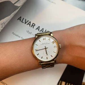Marc Jacobs klocka - Marc Jacobs klocka i guldfärg med vit urtavla, behöver nog byta batteri samt lite sliten i färgen. Låda samt extradelar till länken följer med om man vill ändra storleken.