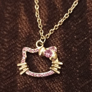 Hello kitty halsband - Hello Kitty halsband i silver med lila stenar, köpt på Depop men använde kanske 2 gånger 💜 runt 3 cm stor, kedja ingår