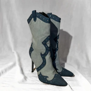 Denim cowboy boots - Supersöta cowboy boots i stl 39. 2 olika denim färger och rhinestones längs sömmarna. De har en stilettklack på ca 11cm och spetsig tå. Knappt använda, bara synligt under skon men knappas något där ändå.  Kunden står för frakt, som betalas separat. Postas så snabbt som möjligt.  Om du har frågor eller vill de fler bilder på plagget är det bara att skicka ett meddelande. 