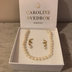 Pärlhalsband, örhängen Caroline Svedbom - Fint och klassiskt set med örhängen och halsband från Caroline Svedbom. Nya i kartong.
