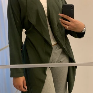 Kappa - Jätte fin mörkgrå kappa. Köpt för ca 1 år sedan men använd endast 2 gånger, säljer den då det inte är min stil längre. Kappan är i storlek L men är liten i storleken, den går ner till knäna på mig.